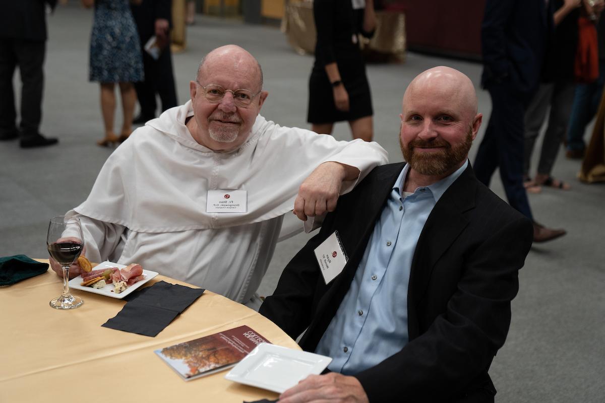 Fr Stan with Campus Safety's Ryan Wendt sitting at a table