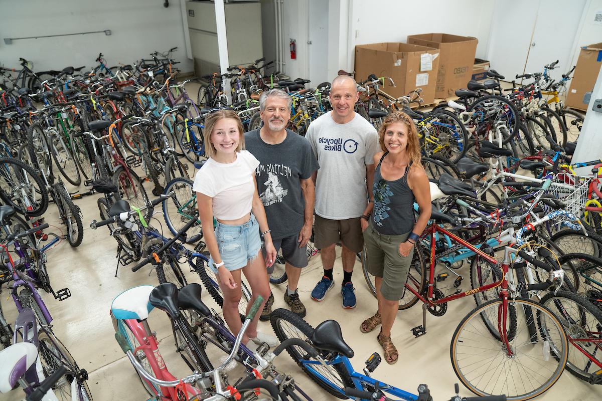 Dr. 伦德鲁姆和卡明斯与“升级自行车”的两名成员，周围是捐赠的自行车