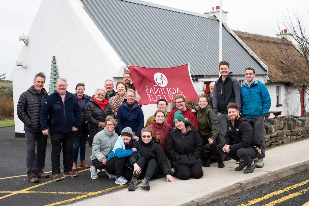 People pose in front of Aquinas Flag in Ireland